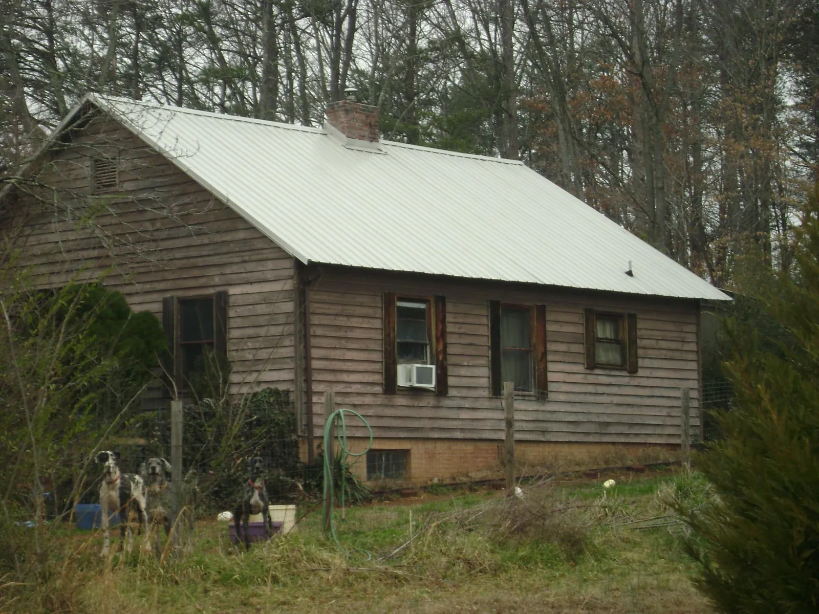 White metal roof on an old wood sided farmhouse, from a Metal Roof Installation job in Utica